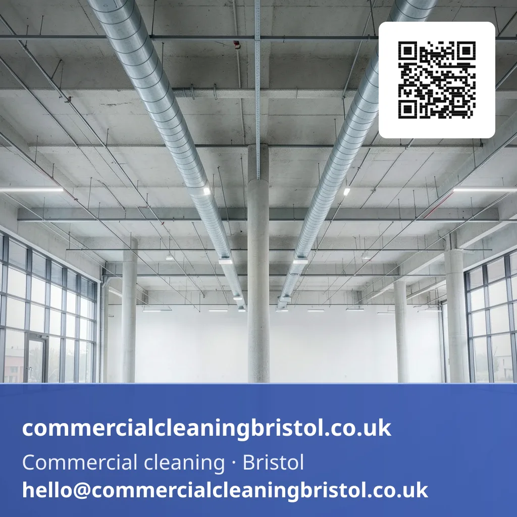 High-dusting pole reaching a run of exposed ceiling ductwork above a large open-plan floor