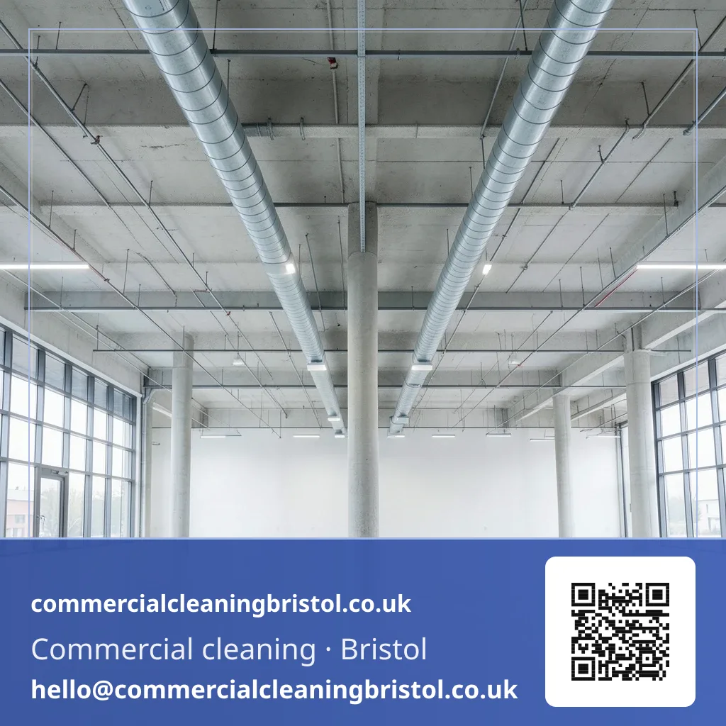 High-dusting pole reaching a run of exposed ceiling ductwork above a large open-plan floor