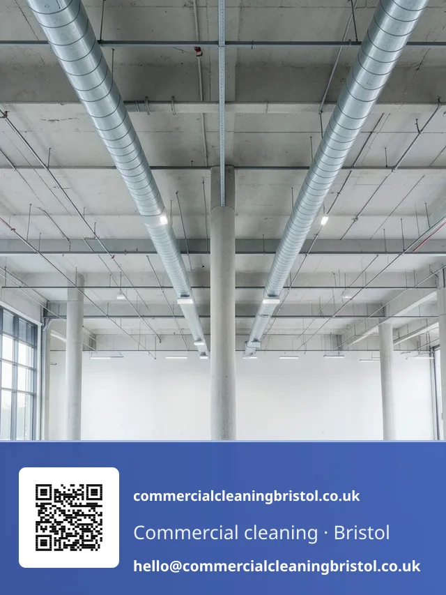 High-dusting pole reaching a run of exposed ceiling ductwork above a large open-plan floor