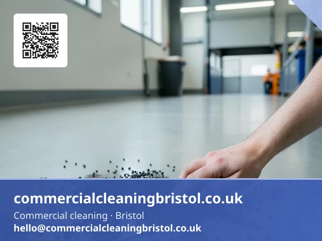 Absorbent granules scattered by hand across a small spill on a warehouse office floor