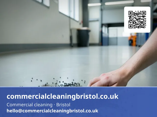 Absorbent granules scattered by hand across a small spill on a warehouse office floor