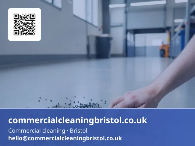 Absorbent granules scattered by hand across a small spill on a warehouse office floor