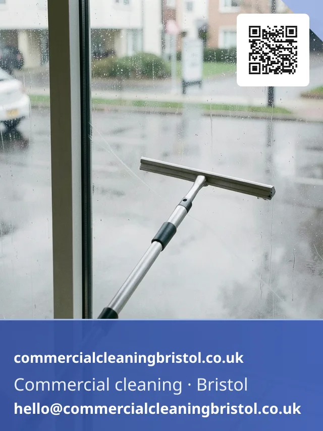 Window squeegee on a short extension pole wiping a streak-free arc across a ground-floor shopfront window from the inside