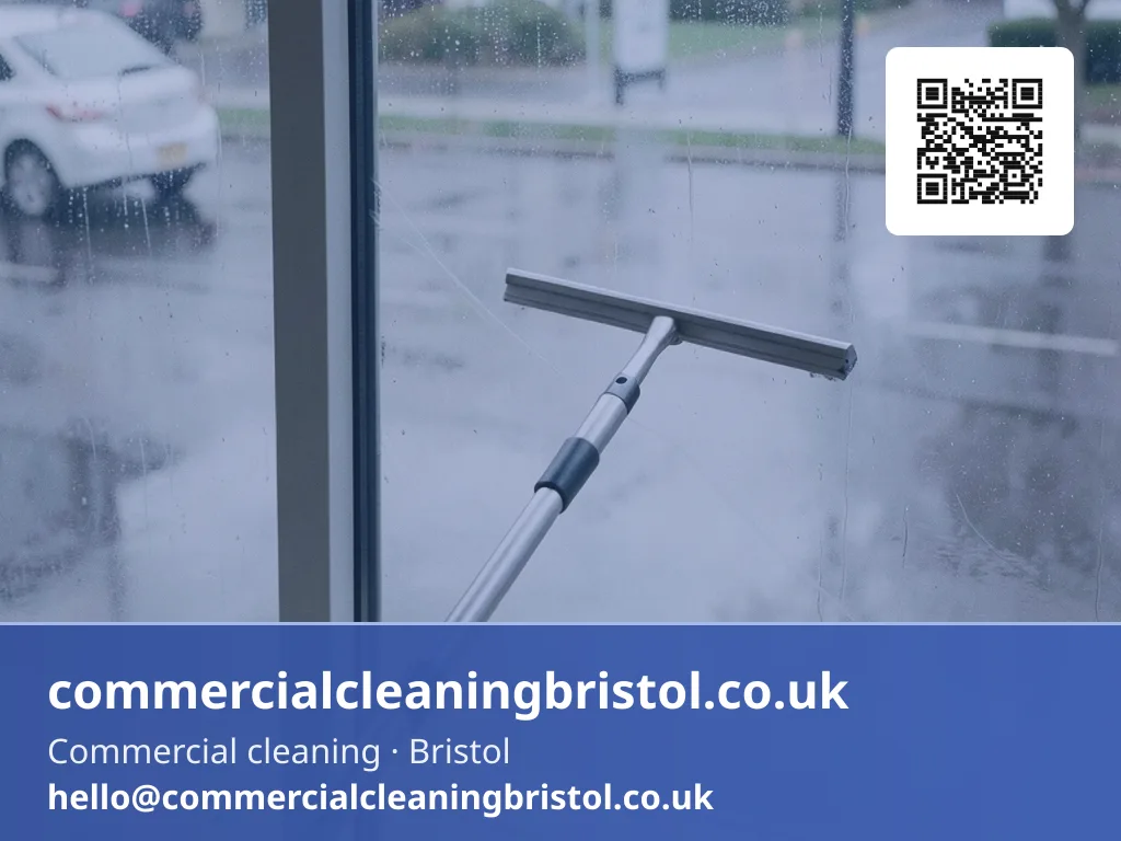 Window squeegee on a short extension pole wiping a streak-free arc across a ground-floor shopfront window from the inside