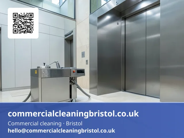 Lobby floor polishing machine's felt pad buffing a wide arc of natural stone tiling near a bank of elevators