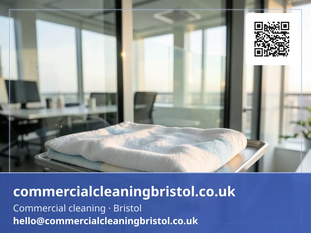 Pair of colour-coded microfibre cloths folded on a cleaning caddy beside a glass partition