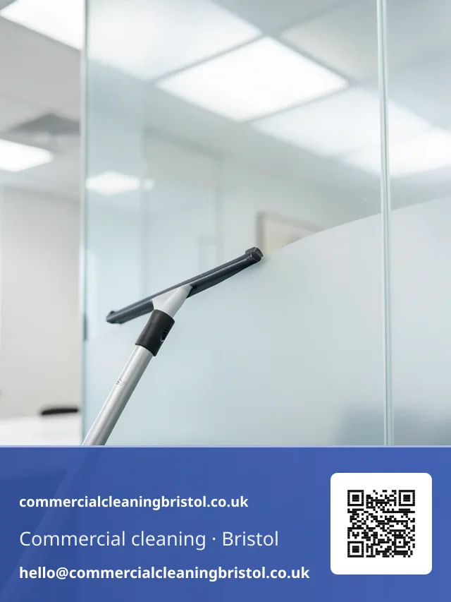 Window squeegee on a short pole wiping a streak-free arc across an internal glazed partition